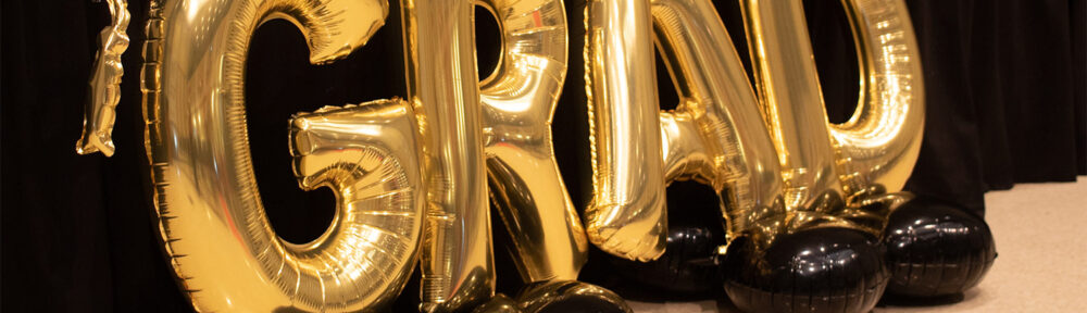 Golden balloons spelling grad
