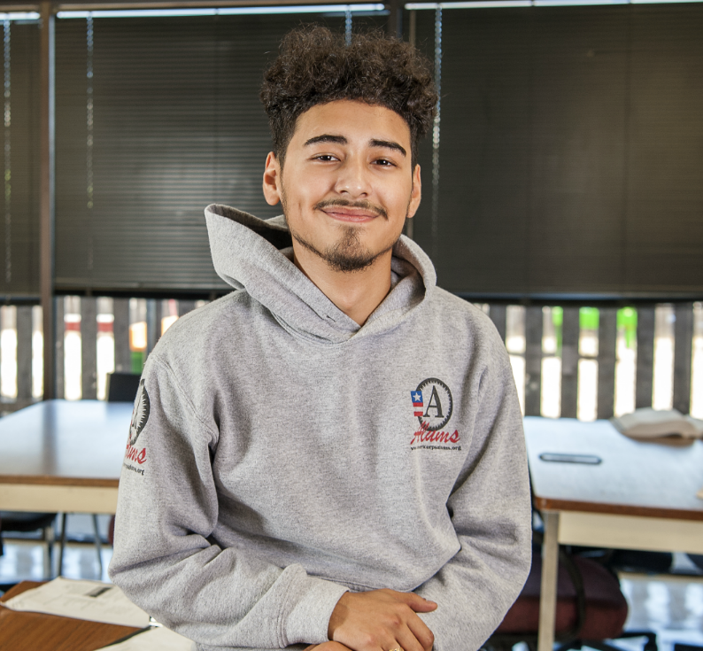 A YouthBuild Austin participant smiling and looking into the camera.