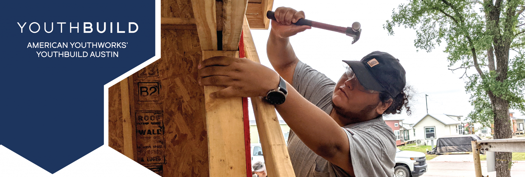 The YouthBuild Austin logo, and a close up of a YouthBuild Austin participant using a hammer and nail to build a house.