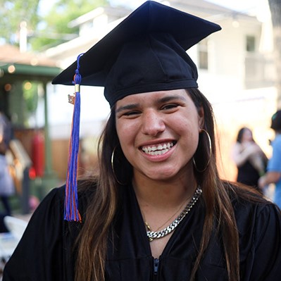 Headshot of a YouthBuild Austin graduate in their cap and gown.