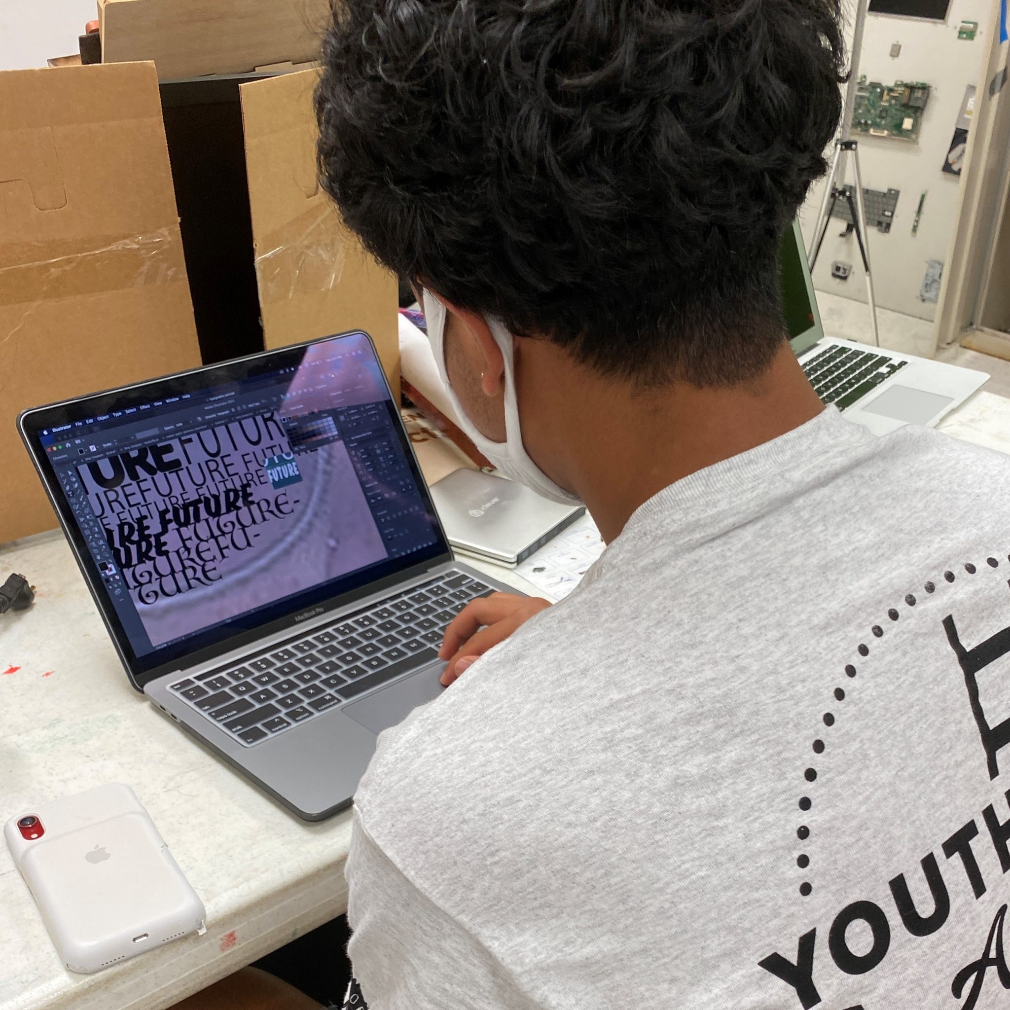 A Media Corps participant using the Adobe programs to create a t-shirt design.