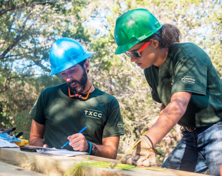 Two conservation corps members reviewing a project plan.