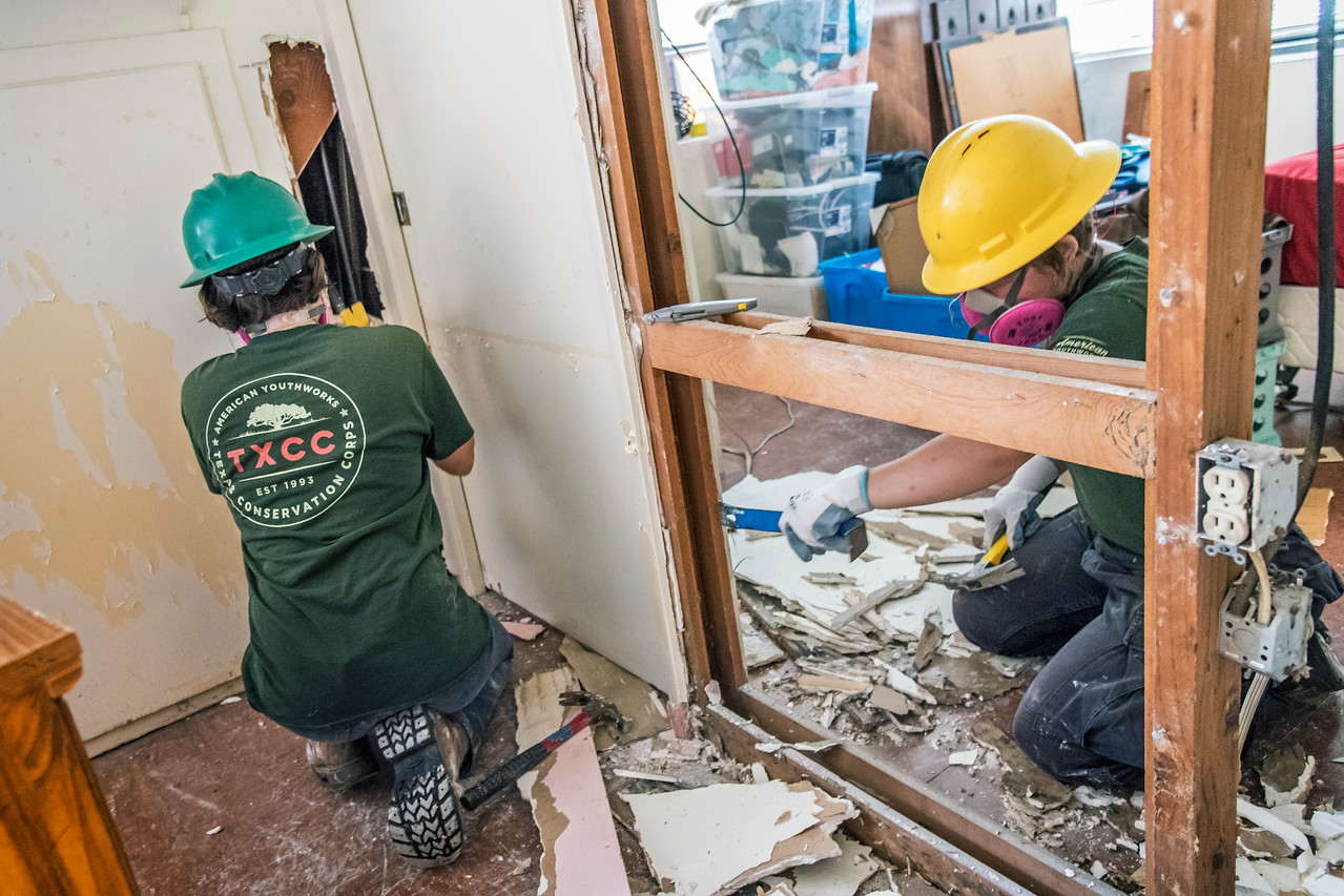While on a disaster response deployment, Conservation Corps program participants are mucking and gutting inside a home.