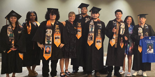 Graduates from the YouthBuild program in Taylor, in cap in gown.