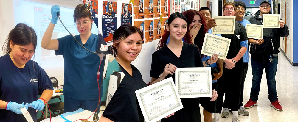 Health care participants learning skills and holding up certificates.